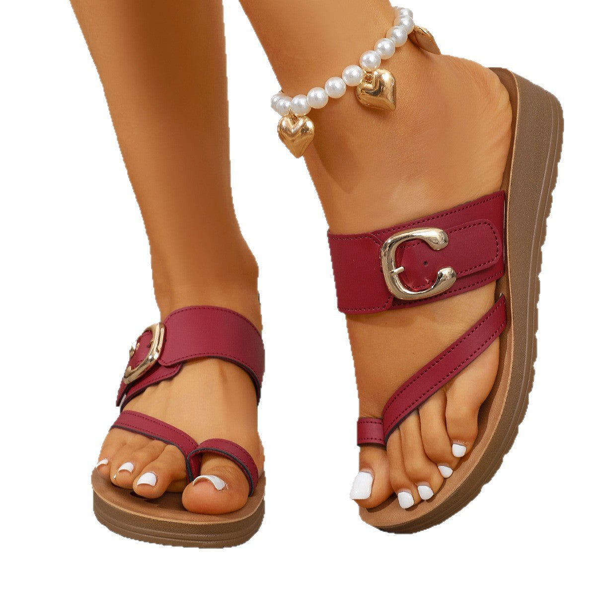 Close-up of a sandal with a red strap and gold buckle on a white background