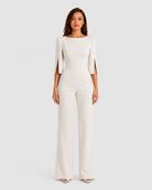 Woman wearing a white jumpsuit on a plain background