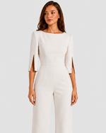 Woman wearing a white jumpsuit on a light gray background