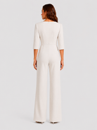 Woman wearing a white jumpsuit on a light gray background