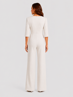 Woman wearing a white jumpsuit on a light gray background