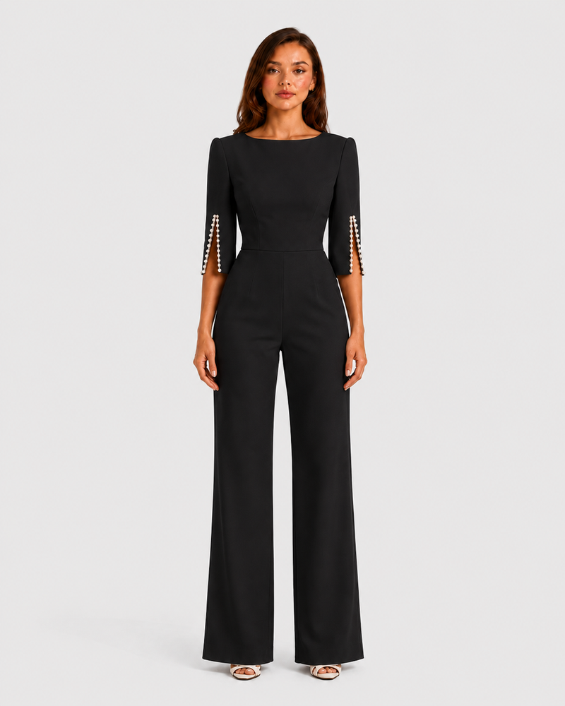 Woman wearing a black jumpsuit with metallic cuffs on a white background