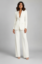 Woman wearing a white suit against a gray background