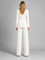 Woman wearing a white suit on a gray background