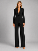 Woman wearing a black suit on a gray background