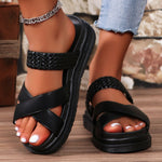 Black sandals worn on feet with a blurred background