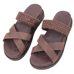 Pair of brown sandals with woven straps on a white background