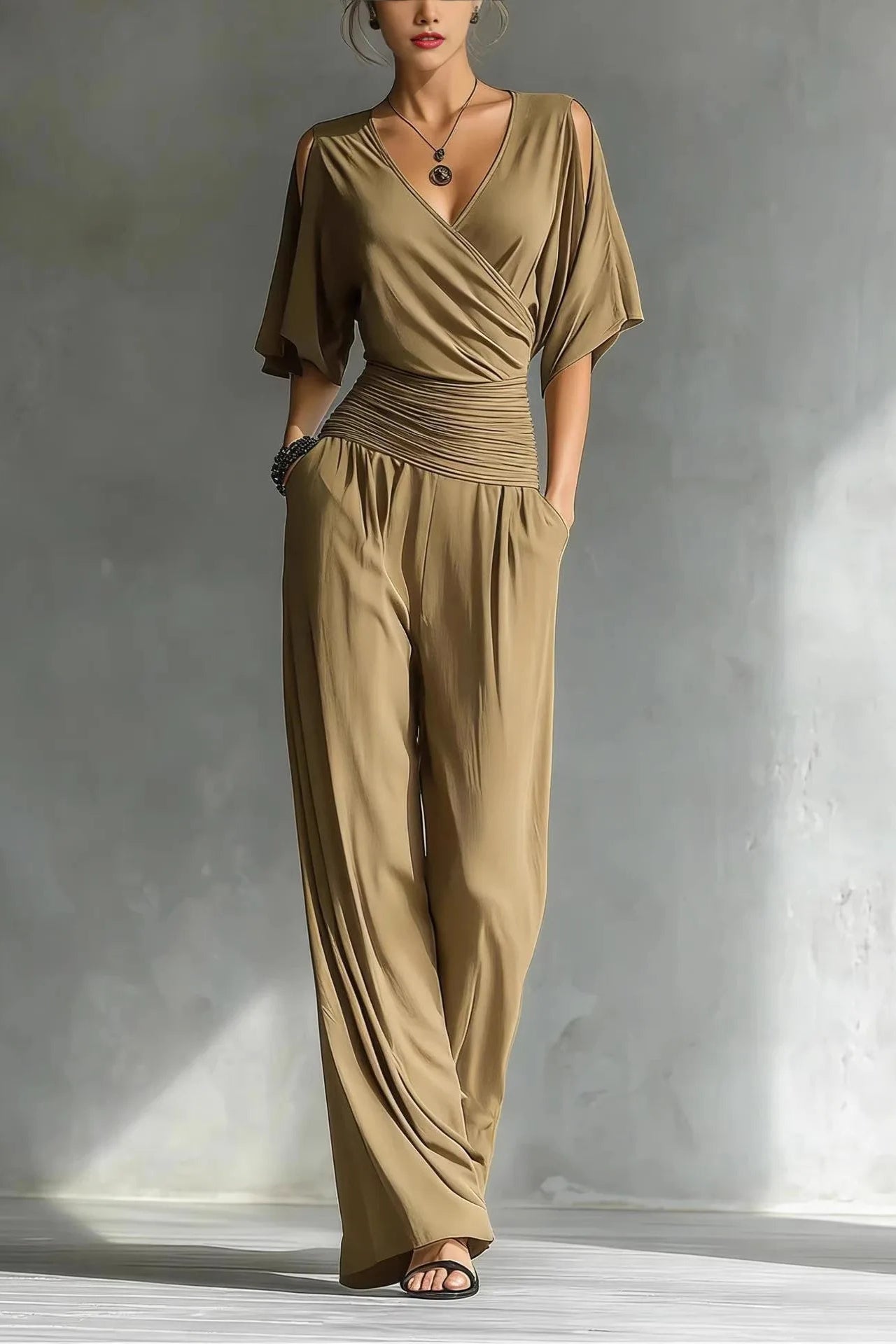 Woman wearing a beige jumpsuit against a gray background