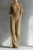 Woman wearing a beige jumpsuit against a gray background